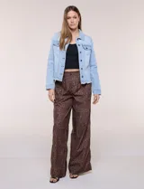 Campera de jean Baccini de color celeste claro, con cuello solapa, cierre frontal con botones metálicos, bolsillos en el pecho y ruedo con terminación desflecada.