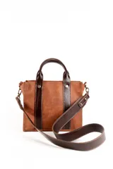 Cartera marrón de cuero con doble asa corta y correa larga desmontable.