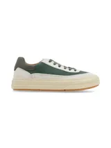 Sneaker de diseño urbano con combinación de texturas y colores, presentando paneles en verde oscuro y cuero texturizado en tono crudo, con suela de plataforma en color crema y base de goma.