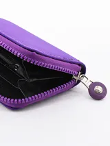 Billetera pequeña de diseño compacto en color violeta, con cierre perimetral y logo circular grabado en el frente.