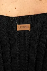 Cardigan negro de algodón con cuello en V, cierre frontal de botones y mangas largas con textura calada. Presenta puños y ruedo acanalados.