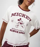 Remera de pijama de viscolycra blanca con cuello redondo y mangas cortas en color bordó. Presenta una estampa frontal vintage de Mickey Mouse con texto.