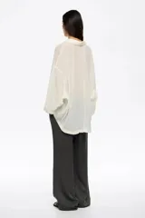 Pantalón de corte recto y tiro bajo, color crudo, con bolsillos frontales tipo alforja y cintura ajustable con cordón.