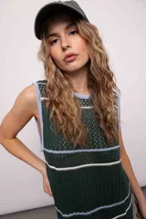 Vestido largo tejido de punto color verde con rayas horizontales blancas y celestes, con tajos laterales y cuello redondo.