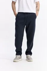 Pantalón de algodón color azul marino, estilo jogging, sin puño en la parte inferior, con elástico y cordón ajustable en la cintura.