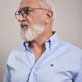 Camisa de vestir celeste a rayas verticales blancas, de corte clásico, con cuello abotonado y manga larga.