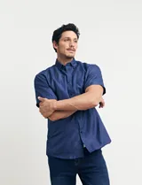 Camisa azul con estampado de lunares blancos, de manga corta y corte clásico.