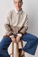 Sweater de tejido jacquard con diseño de rayas verticales en tonos rojo, blanco y azul. Presenta cuello redondo, hombros caídos y puños en contraste de color azul.