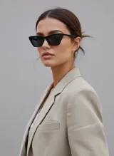 Lentes de sol de mujer con montura negra de policarbonato brillante, diseño rectangular con forma de ojo de gato sutil. Lentes oscuros.