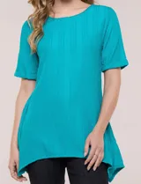 Blusa blanca de tejido de punto liviano con textura labrada en franjas verticales y caladas, de silueta evasé, con escote redondo, manga corta y ruedo asimétrico en picos.