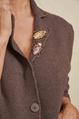 Prendedor de bijouterie con diseño de insecto, realizado en metal con esmalte mate en tonos tostado y marrón oscuro con detalles pintados.