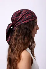 Pañuelo cuadrado de seda con diseño estampado de letras en color rojo sobre fondo negro.