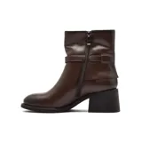 Bota de caña media confeccionada en cuero color marrón, con taco cuadrado bajo y detalle de tira con hebilla metálica en el tobillo.