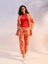 Blazer color crema de manga larga, con solapas amplias y cinturón para ajustar a la cintura.