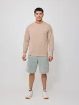 Sweater color arena con logo Rusty estampado en el pecho, de corte regular fit.