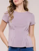 Remera básica de manga corta y cuello redondo, color beige, con detalle de alforzas verticales en el frente que aportan estructura.