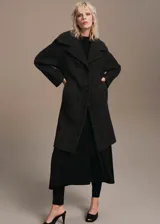 Abrigo de corte oversize con diseño de cuadros, cuello con solapas de muesca, cierre frontal con botones, dos bolsillos laterales y forro interior.