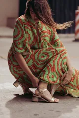 Sandalias plateadas con tira ancha sobre los dedos, tira fina con hebilla al tobillo y taco cuadrado bajo.