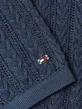 Sweater azul marino de tejido de punto calado con rayas verticales blancas, cuello polo y tapeta con tres botones.