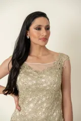 Vestido dorado de cruni con escote y espalda de tul transparente.