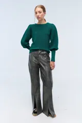 Sweater color crema de tejido de punto con lurex, mangas abullonadas y puños con botones metálicos.