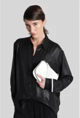 Camisa de mujer Diesel modelo C-Simplier, de manga larga y cierre frontal con botones, confeccionada en poliéster técnico con acabado brillante efecto cuero. Cuenta con bajo trasero alargado y logo Oval D bordado en el pecho.