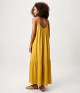 Vestido largo mostaza de viscolino con escote en U, breteles finos y corte evasé con caída fluida. Cuenta con un recorte fruncido en el ruedo.