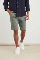 Bermuda de gabardina color verde medio, con corte clásico, bolsillos laterales y cierre frontal con botón.