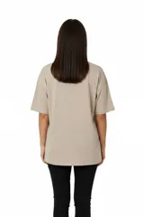 Remera de algodón color beige con cuello redondo y mangas cortas. Presenta un estampado frontal en color blanco con motivos festivos y la frase 'Slice, Sip, Spill'.