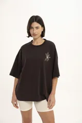 Remera marrón de corte holgado con estampado de una flor en el pecho.