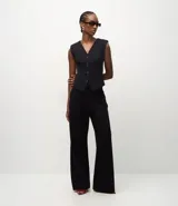Pantalón de corte recto y estilo sastre, confeccionado en tejido punto roma con caída estructurada. Presenta un diseño minimalista y elegante con cintura definida.