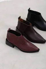Botineta de cuero negro con textura sutil, con elásticos laterales y taco cuadrado bajo.