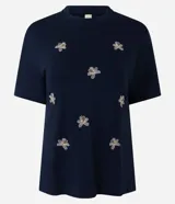 Remera Marfinno de viscosa azul marino con cuello redondo y mangas cortas. Cuenta con pequeños bordados florales distribuidos en el frente.