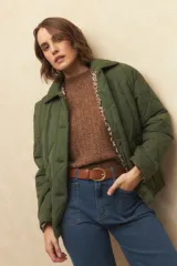 Campera capitoneada negra con botones veteados, bolsillos laterales de solapa y forro de satén con estampado animal print.