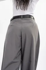 Pantalón de vestir gris de corte sastrero, con pinzas frontales, diseño de pierna ultra ancha y tiro medio.