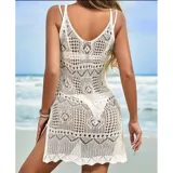 Vestido corto de playa tejido en crochet con diseño calado, cuello redondo y tajo lateral. Presenta un corte ajustado y sin mangas.