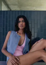Top sin mangas estilo chaleco confeccionado en tejido de algodón tipo denim. Presenta un diseño recto, cuello redondo y cierre frontal con botones.