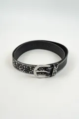 Cinturón negro con tachas metálicas circulares y en forma de estrella, con hebilla metálica plateada.
