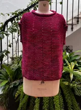 Chaleco tejido a mano en dos agujas con hilado 100% baby alpaca teñido artesanalmente, color magenta matizado. Diseño ligeramente oversize, de hombros anchos y cuello tipo bote, con puntos calados en frente y espalda y tajos a los lados en el bajo.