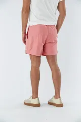 Short de baño liso color salmón, con cintura elástica ajustable mediante cordón, dos bolsillos laterales y un bolsillo posterior.