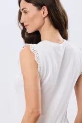 Musculosa de algodón color azul con detalles de broderie calado en los hombros, de cuello redondo y corte clásico.
