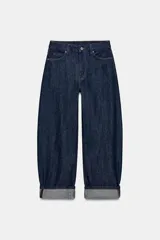 Jeans de tiro medio con diseño de pierna tipo balloon y corte full length. Presenta cintura con trabillas, cinco bolsillos clásicos, cierre frontal con cremallera y botón, y bajo con acabado en vuelta.