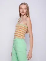 Top tejido de punto con tramado calado a rayas horizontales en tonos verde, naranja y rosa. Diseño de un solo hombro.