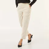 Pantalón de vestir corte pitillo en color beige, con diseño liso, cierre frontal y bolsillos laterales.