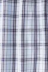 Pantalón de popelina de algodón a cuadros en tonos celeste, blanco y azul marino. Presenta cintura elástica con cordón ajustable, cierre decorativo y bolsillos laterales. Corte relajado.