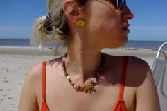 Aros tipo botón dorados con textura irregular que simula la superficie de un molusco.