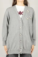 Cardigan oversize color gris melange, con escote en V, cierre frontal con botones y broches decorativos con perlas.