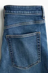 Jean de tiro alto y cinco bolsillos confeccionado en denim azul con leve elasticidad. Presenta un corte ajustado desde la cintura hasta las caderas y diseño acampanado desde la rodilla hacia el bajo.