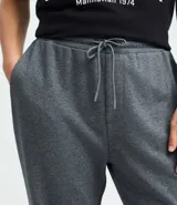 Pantalón tipo jogger de color negro, confeccionado en una mezcla de algodón y poliéster. Presenta cintura elástica con cordón ajustable, bolsillos laterales y puños elásticos en el ruedo.