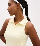 Vestido deportivo evasé color amarillo claro, confeccionado en microfibra. Presenta cuello polo con escote en V, diseño sin mangas y short interno incorporado con bolsillo lateral.